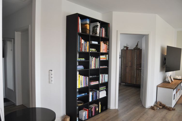 Ferienhaus Lieblingsplatz der Wohnbereich mit einem Bücherrehal